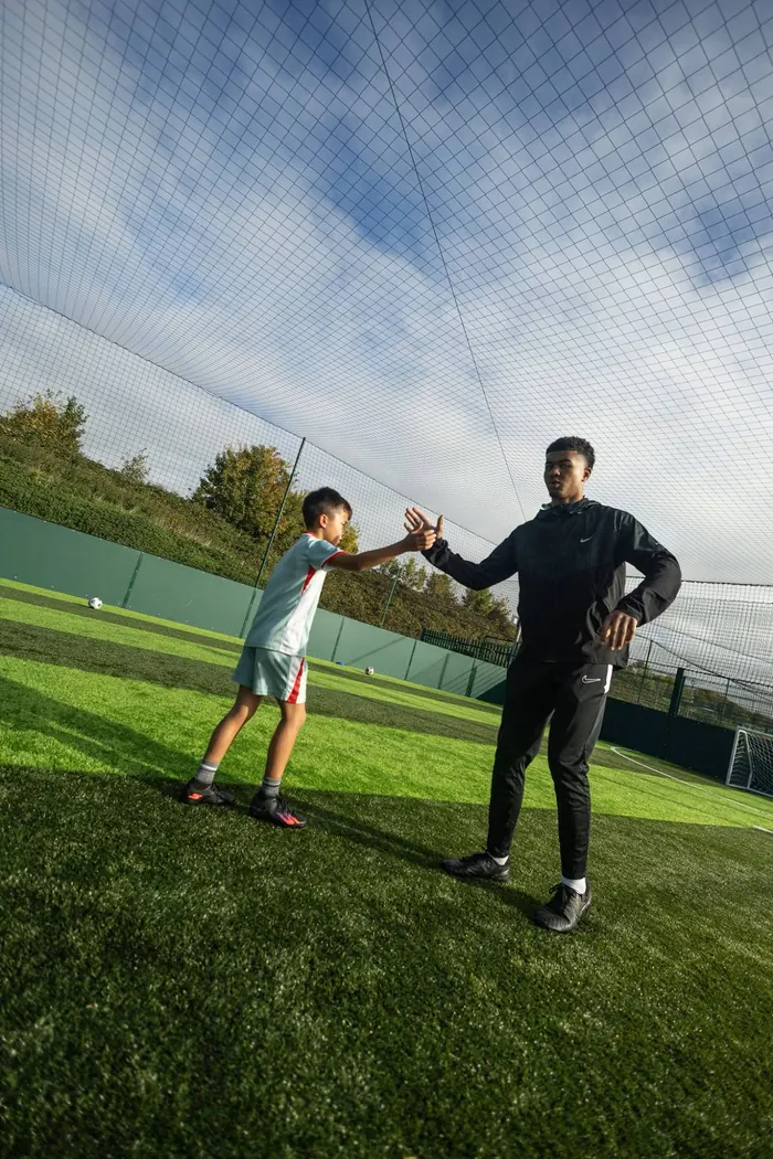 The coach and a young player sharing a high five