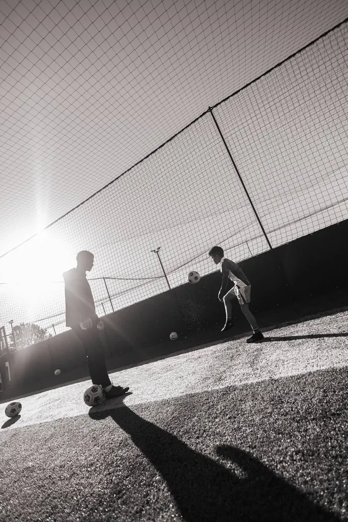 Coach and player in the low sun, in black and white