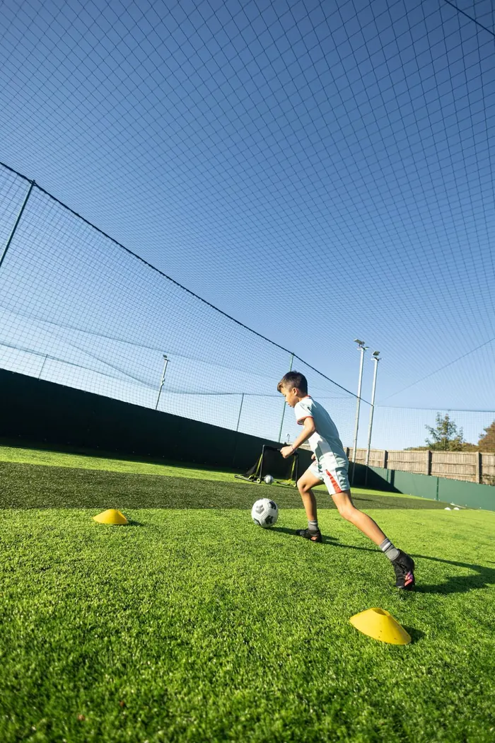 A young player training under a clear blue sky